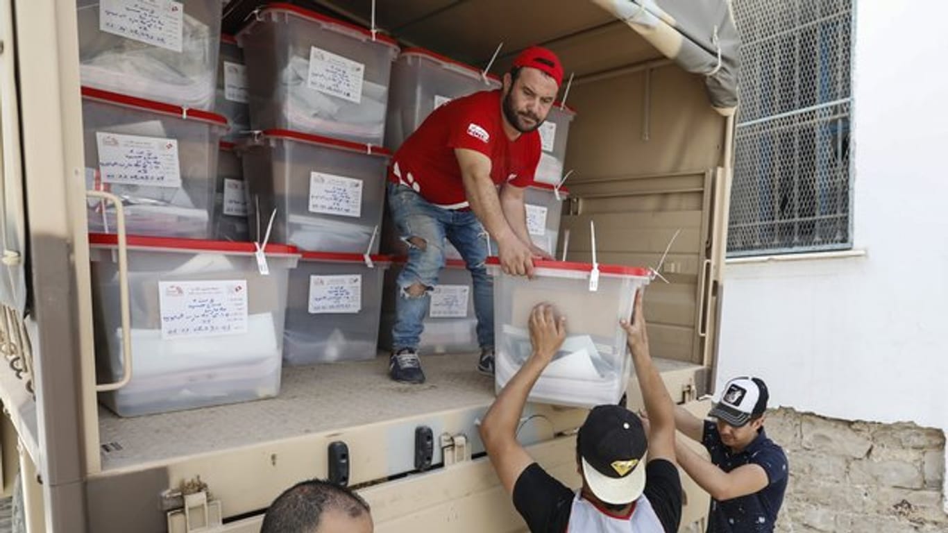 Männer verteilen Wahlurnen und Wahlmaterial in Tunis.