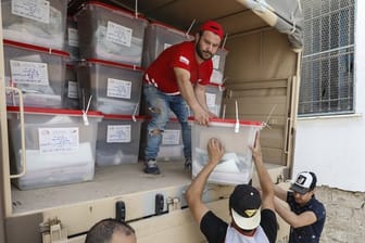 Männer verteilen Wahlurnen und Wahlmaterial in Tunis.