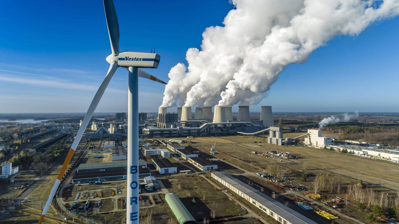 Braunkohlekraftwerk mit Windrad: Noch sind die genauen Maßnahmen des Klimapakets unklar. Das gilt auch für die zu erwartenden Kosten.