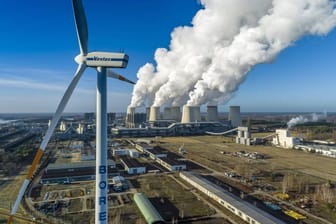 Braunkohlekraftwerk mit Windrad: Noch sind die genauen Maßnahmen des Klimapakets unklar. Das gilt auch für die zu erwartenden Kosten.