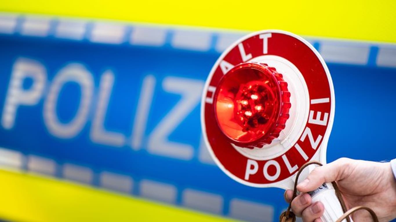 Ein Polizist bittet um Anhalten: In Köln wurden zwei Autofahrer gestoppt, die sich ein illegales Autorennen geliefert haben.