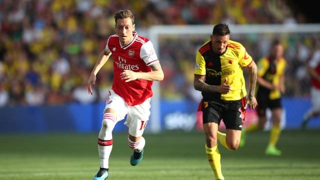 Arsenals Mesut Özil (l) und Jose Holebas von FC Watford im Laufduell.