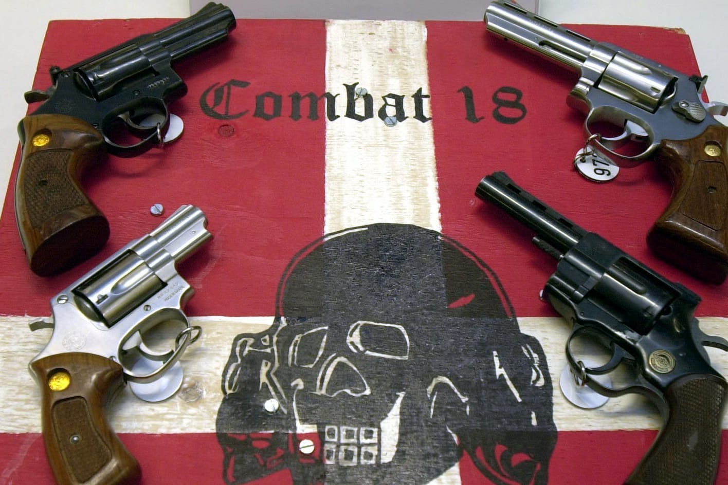 Sichergestellte Waffen und ein Schild der Neonazi-Gruppe "Combat 18" liegen im Jahr 2002 im schleswig-holsteinischen Landeskriminalamt (LKA). Im Zuge einer groß angelegten Aktion hatte die Polizei die Gruppierung "Combat 18" in Norddeutschland zerschlagen.