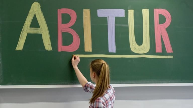 Schülerin unterstreicht "Abitur" an Tafel: Sind gute Noten im Abitur noch Garant für gute Bildung?