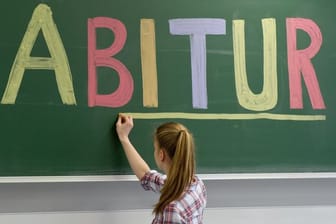 Schülerin unterstreicht "Abitur" an Tafel: Sind gute Noten im Abitur noch Garant für gute Bildung?