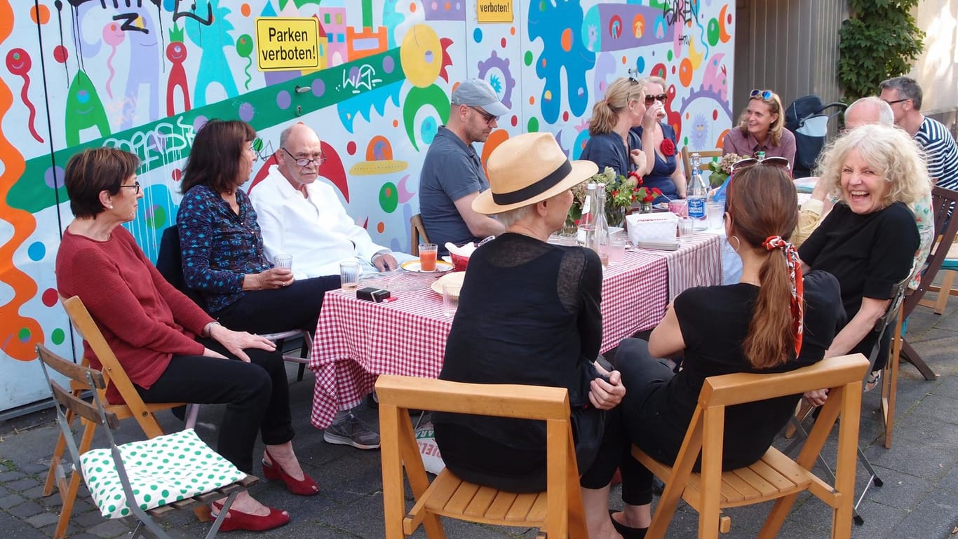 Eine Gruppe sitzt um einen gedeckten Tisch in einer Straße: Die Lessingstraße in Köln war am Sonntag autofrei.