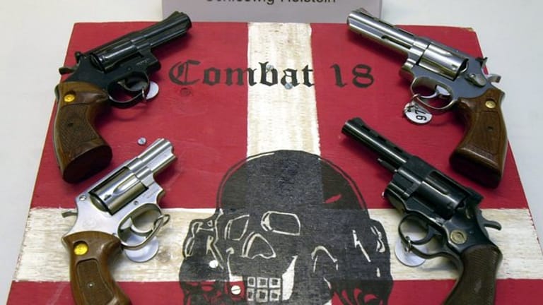 Sichergestellte Waffen und ein Schild der Neonazi-Gruppe "Combat 18" im schleswig-holsteinischen Landeskriminalamt.