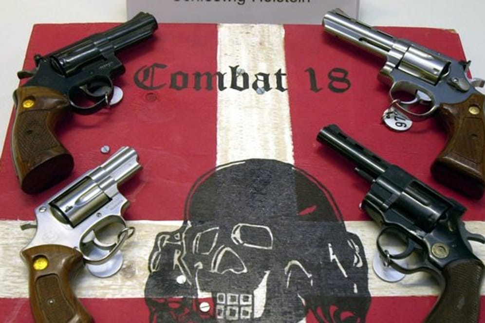 Sichergestellte Waffen und ein Schild der Neonazi-Gruppe "Combat 18" im schleswig-holsteinischen Landeskriminalamt.