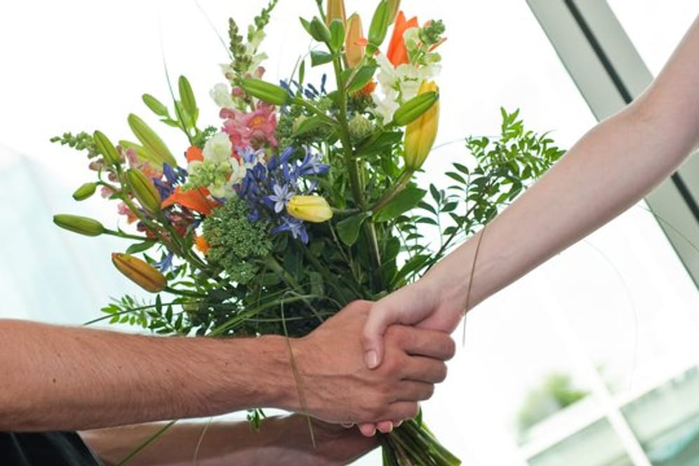 Ein Blumenstrauß wird übergeben: Der Abschied aus dem Berufsleben ist ein wichtiger Moment im Leben.