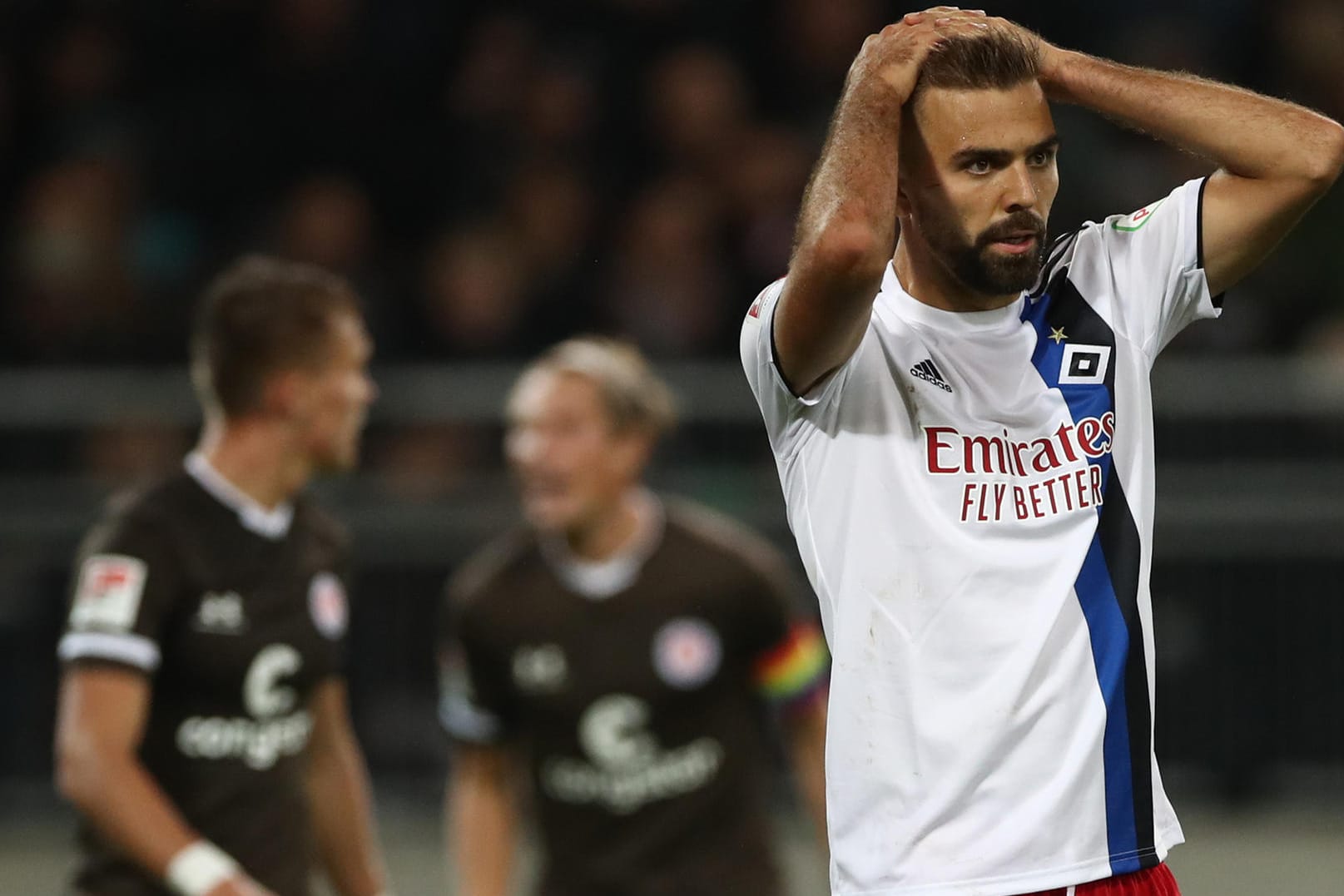 Hamburgs Hinterseer (r.) ist frustiert, hinten jubelt der FC St. Pauli.