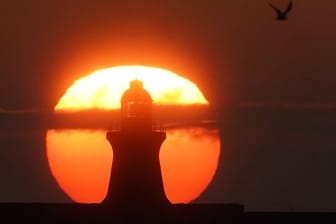 Sonnenaufgang im August hinter dem South Shields Leuchtturm an der Mündung des Tyne in Großbritannien.