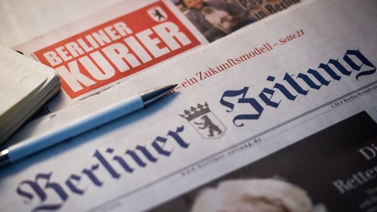 Auf einem Tisch liegen Tageszeitungen: Die "Berliner Zeitung" und der "Berliner Kurier" wurden verkauft.