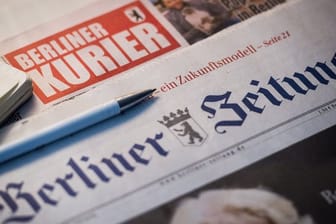 Auf einem Tisch liegen Tageszeitungen: Die "Berliner Zeitung" und der "Berliner Kurier" wurden verkauft.