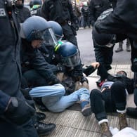 Proteste für Klimaschutz: Ein Demonstrant wird von Polizisten auf dem Boden festgehalten.