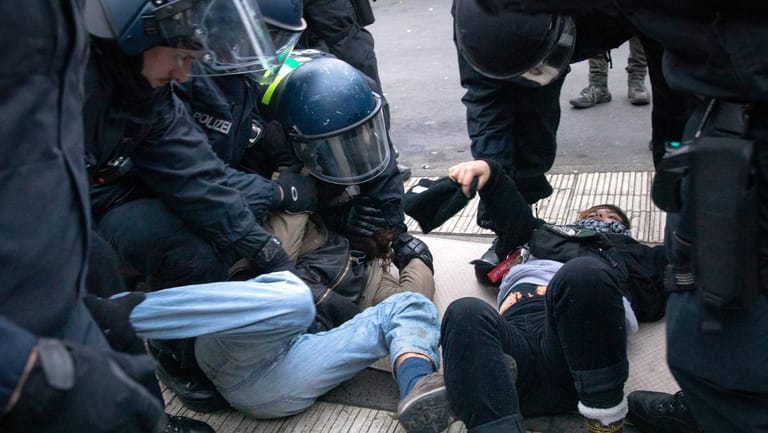 Proteste für Klimaschutz: Ein Demonstrant wird von Polizisten auf dem Boden festgehalten.