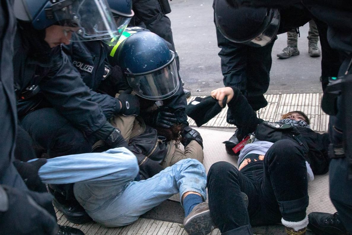 Proteste für Klimaschutz: Ein Demonstrant wird von Polizisten auf dem Boden festgehalten.