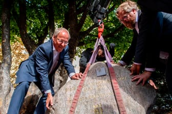 Pit Clausen (rechts) und Achim Held (links): Der Oberbürgermeister von Bielefeld und der Autor der "Bielefeld-Verschwörung" legten den Gedenkstein, der an das Ende der Verschwörungstheorie erinnern soll.