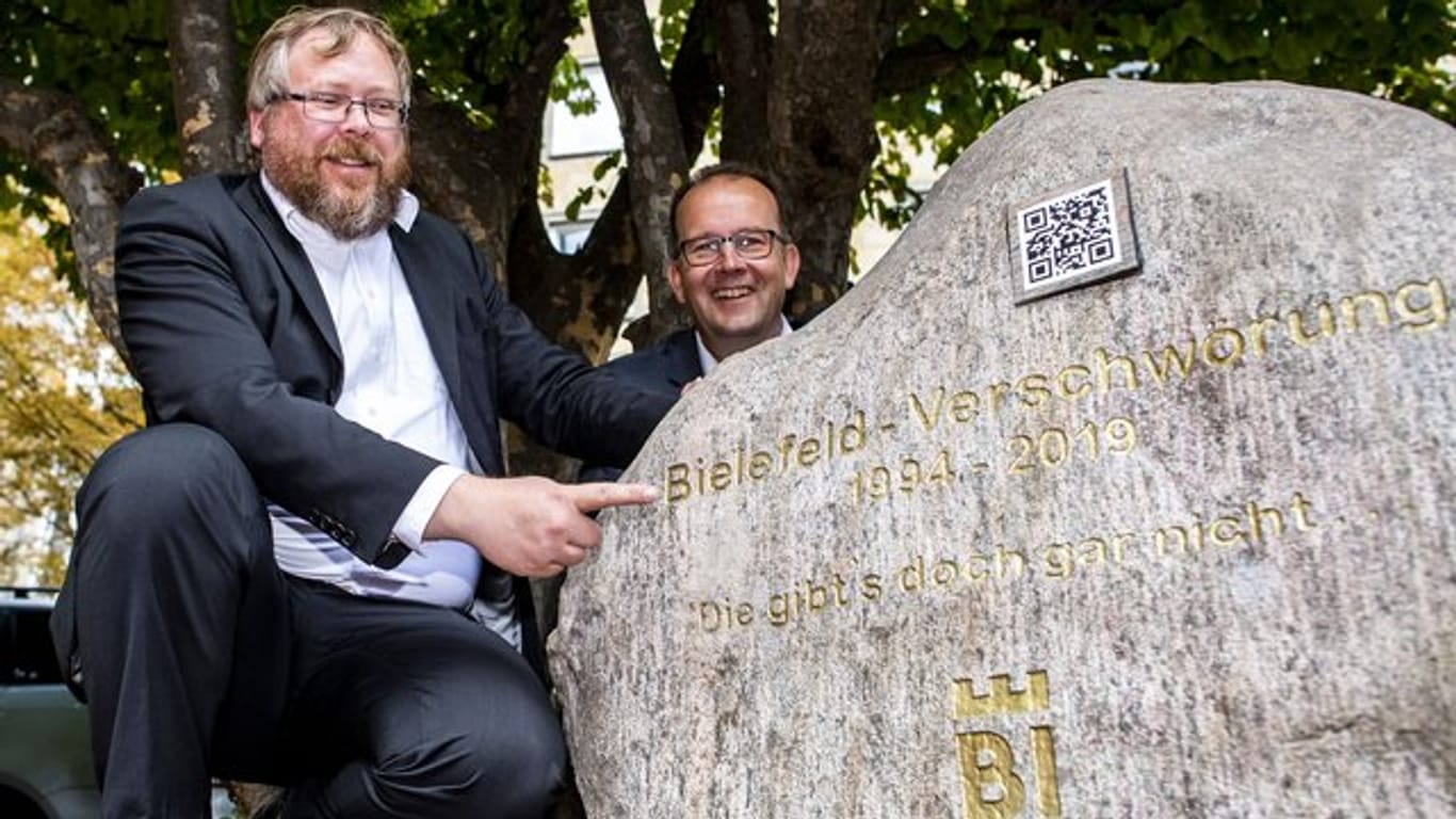 Martin Knabenreich (r), Geschäftsführer Bielefeld Marketing und Achim Held (l), Schöpfer der Bielefeld-Verschwörung, neben dem Denkmal.