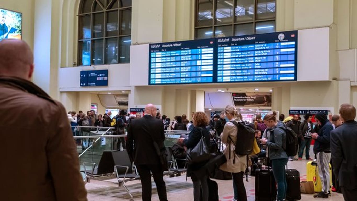 Reisende warten im Hauptbahnhof Hannover.
