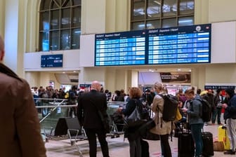 Reisende warten im Hauptbahnhof Hannover.