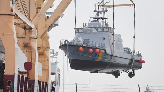 Ein Küstenschutzboot für Saudi-Arabien wird im Hafen von Mukran auf ein Transportschiff verladen.