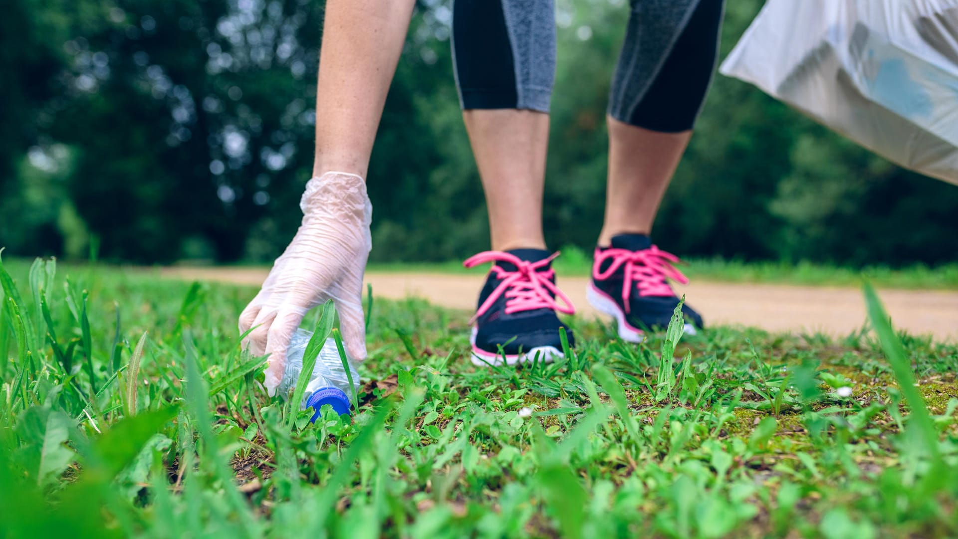 Joggerin sammelt Müll: Plogging verbindet gleichzeitig Umweltschutz und allgemeine Fitness.