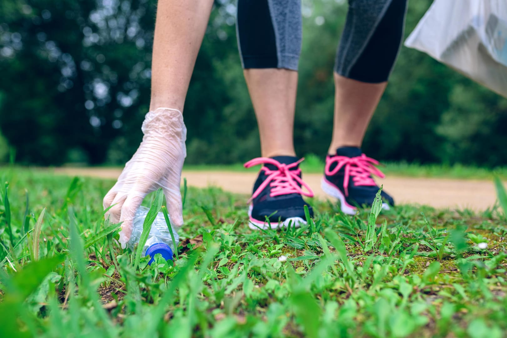 Joggerin sammelt Müll: Plogging verbindet gleichzeitig Umweltschutz und allgemeine Fitness.