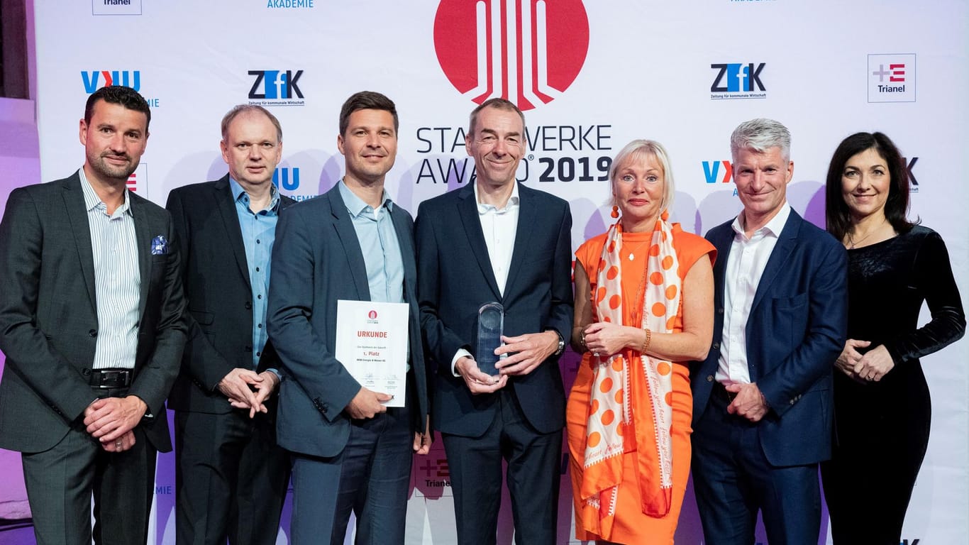 Menschen halten einen Preis in der Hand: Zwei Wuppertaler Unternehmen sind in Kassel mit dem Stadtwerke Award ausgezeichnet worden.