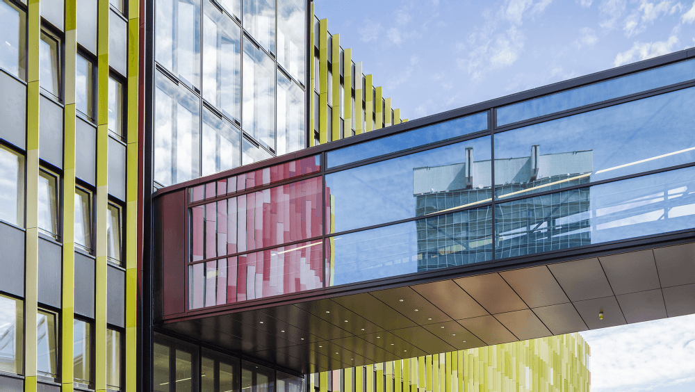 Ein Gebäude in Köln: Das neue Krebszentrum auf dem Gelände der Uniklinik leuchtet je nach Blickrichtung in Rot oder Grün.