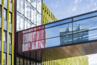 Ein Gebäude in Köln: Das neue Krebszentrum auf dem Gelände der Uniklinik leuchtet je nach Blickrichtung in Rot oder Grün.