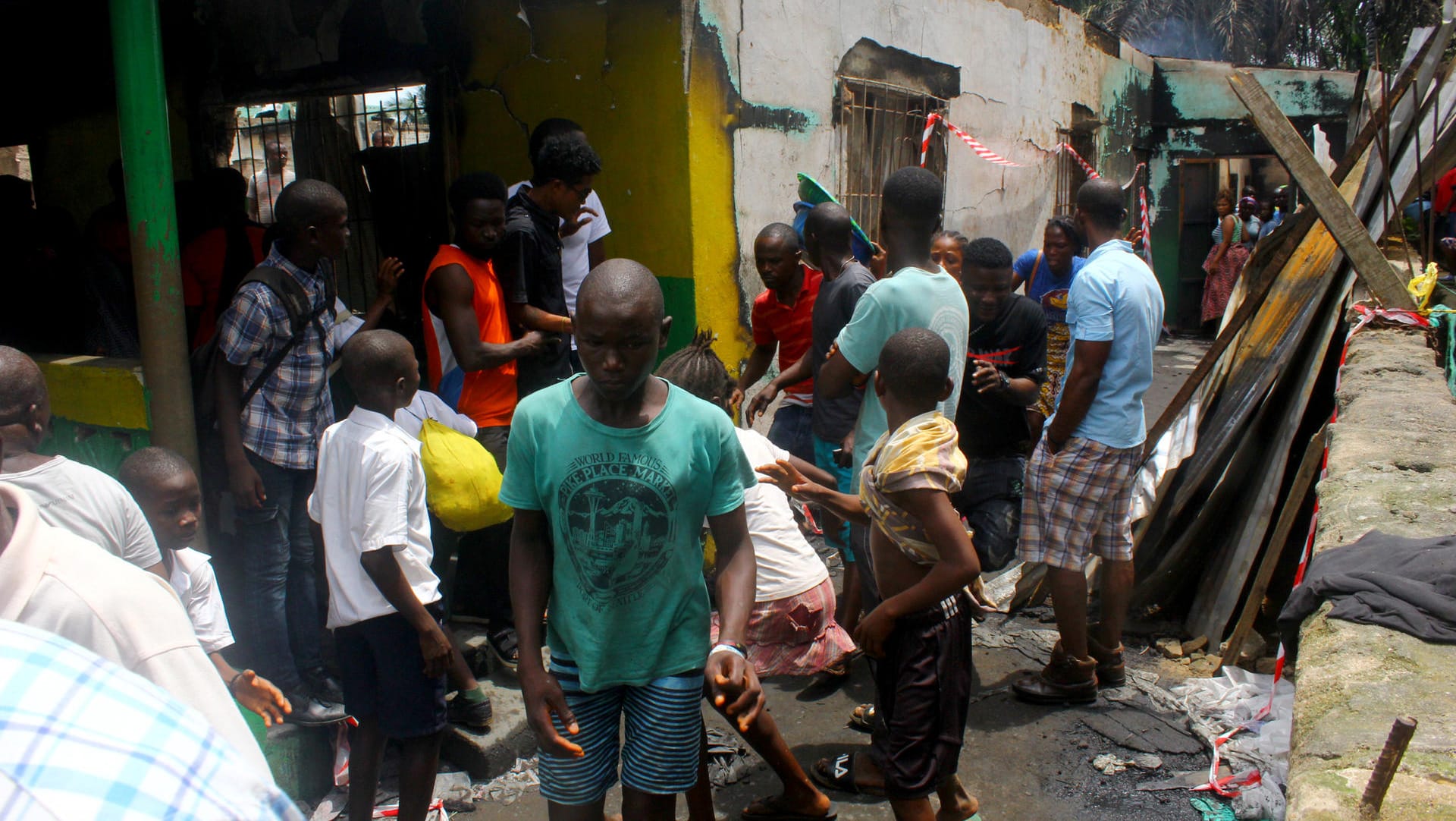 Menschen vor der Ruine der ausgebrannten Schule: Bei dem Feuer in Paynesville nordöstlich der Hauptstadt Monrovia wurden 28 Kinder getötet.