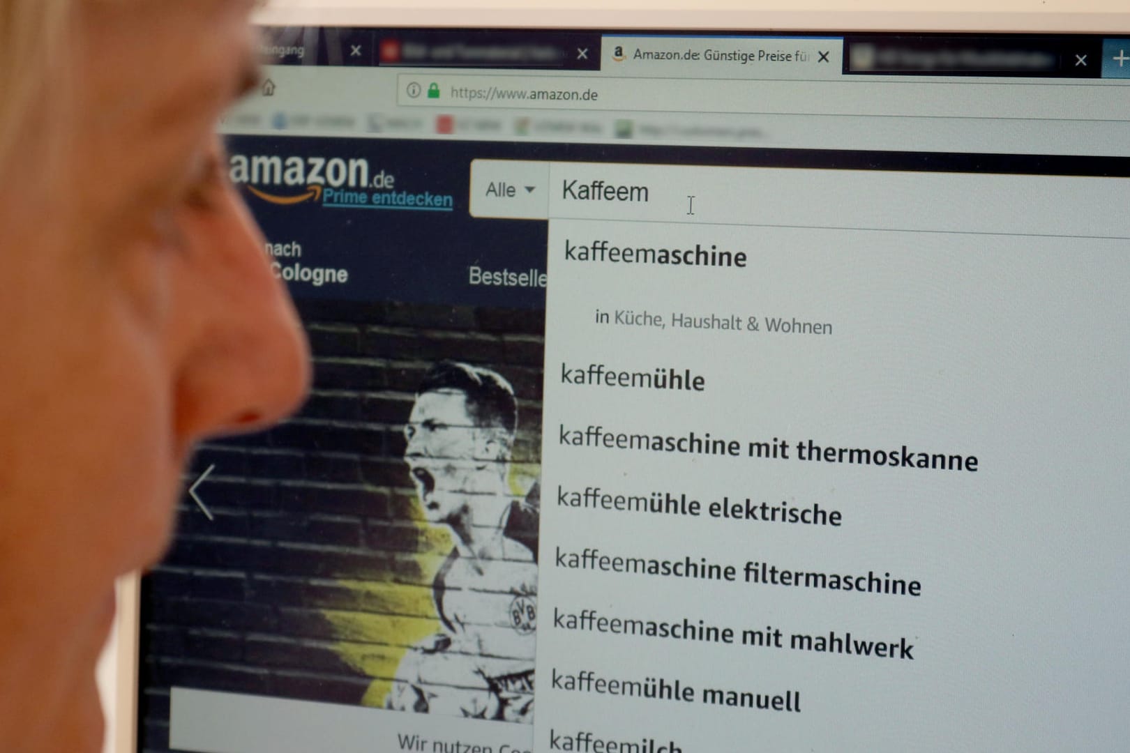 Eine Frau sucht auf Amazon nach Kaffeemaschinen: Eine Analyse der Verbraucherzentrale NRW hat gezeigt, dass viele Produkte auf dem Marketplace zu teuer angeboten werden.