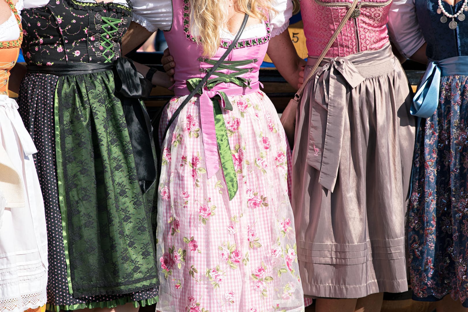 Frau tragen Dirndl: Wer auf der Wiesn Traditionelles trägt, sollte von Sneakers zur Tracht, von T-Shirt unter Dirndl oder von Stoff-Lederhosen absehen.