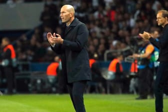 Real-Trainer Zinedine Zidane (l) steckt mit Madrid auch wegen der Niederlage in Paris in Schwierigkeiten.
