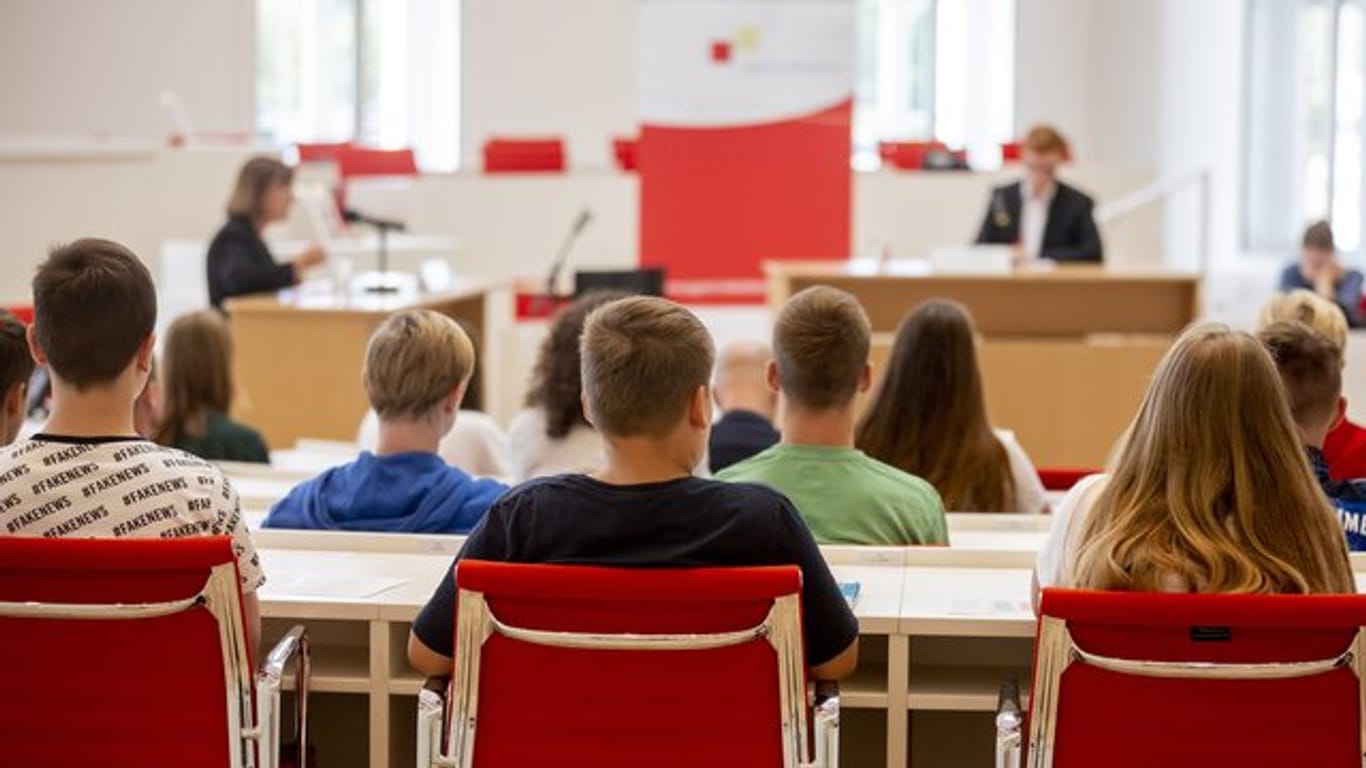 Jugendliche sitzen bei einer Veranstaltung im Plenarsaal des brandenburgischen Landtags.