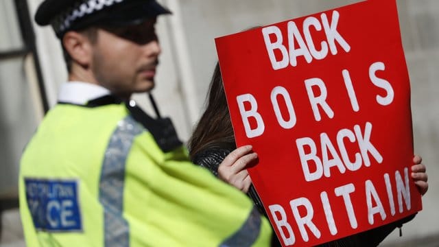 Ein Polizist steht neben einem Pro-Brexit-Demonstranten in London.