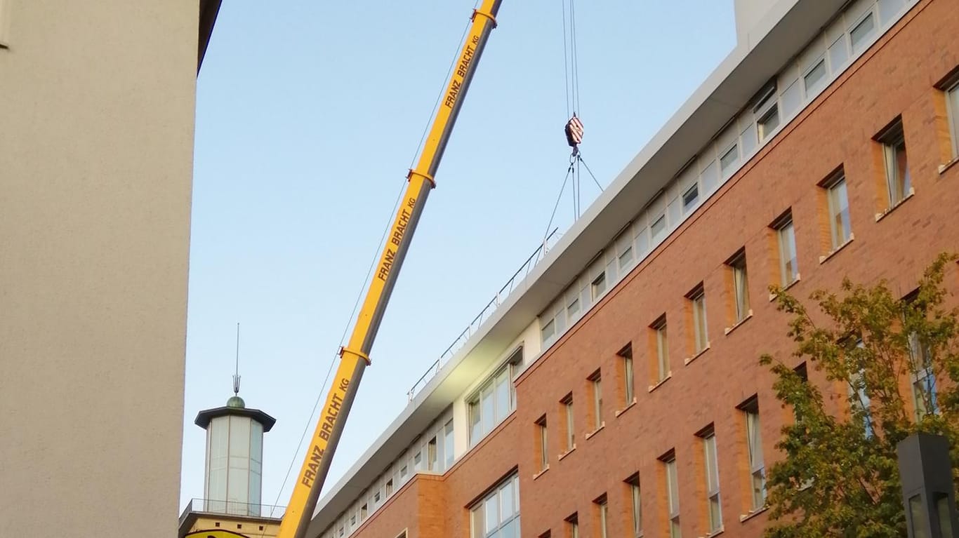Ein Kran steht vor dem Rathaus in Hagen: Das Back-up Rechenzentrum wurde nun auf das Dach gehievt.