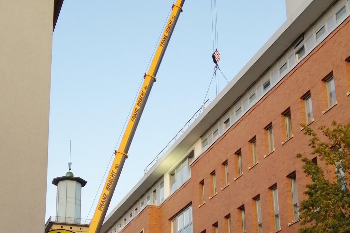 Ein Kran steht vor dem Rathaus in Hagen: Das Back-up Rechenzentrum wurde nun auf das Dach gehievt.