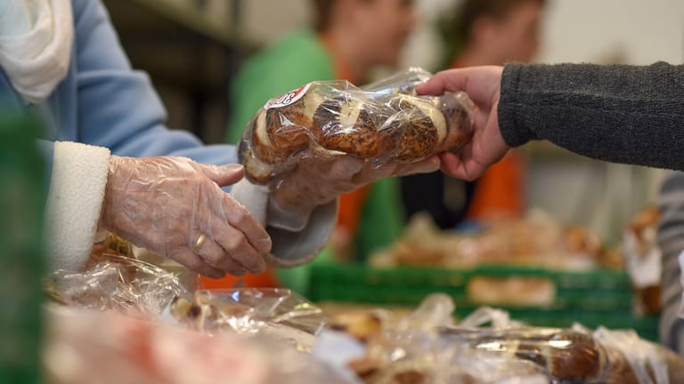 Ein Seniorin erhält ein Brot: Immer mehr ältere Bedürftige kommen zur Wuppertaler Tafel.