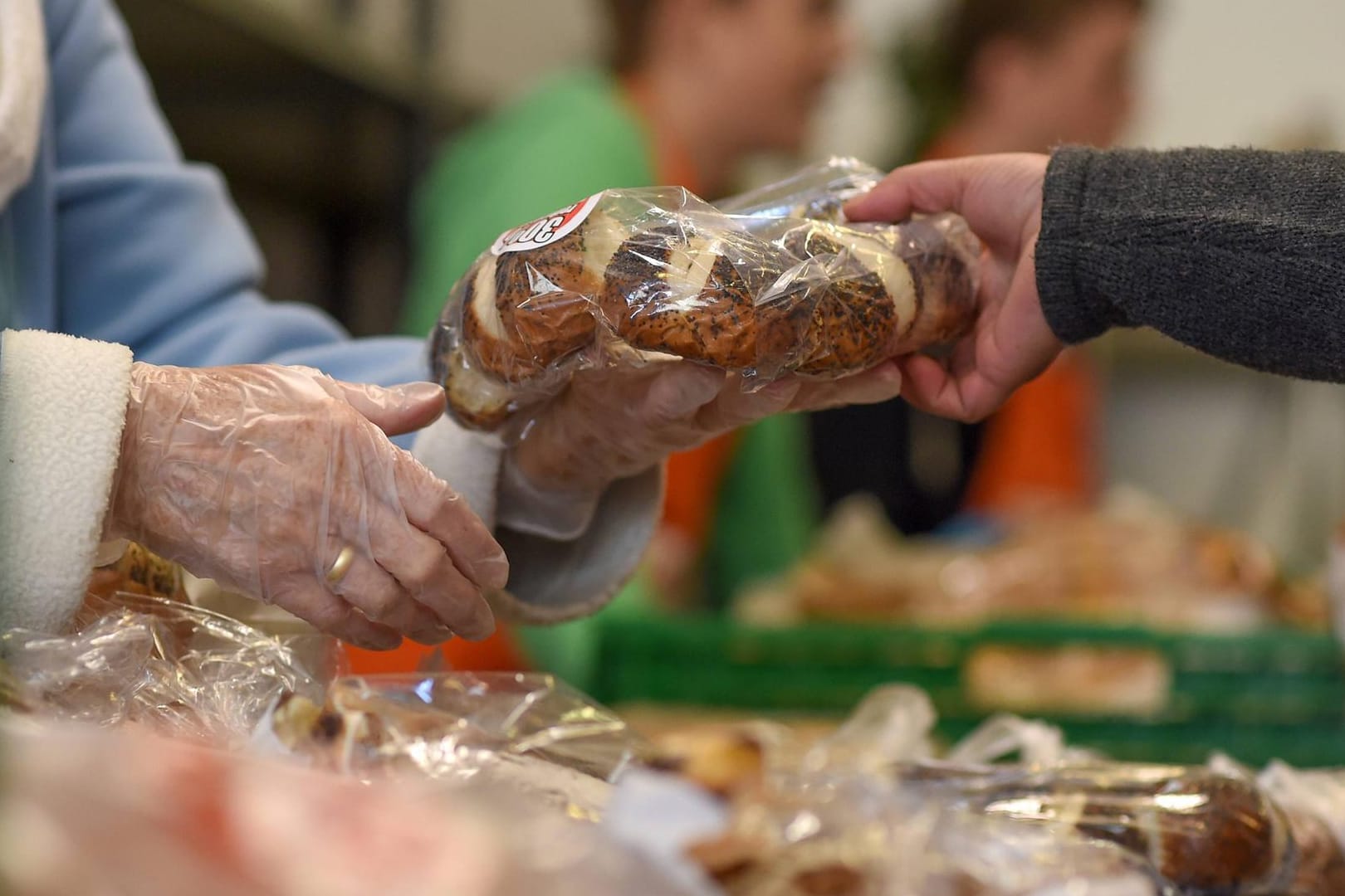 Ein Seniorin erhält ein Brot: Immer mehr ältere Bedürftige kommen zur Wuppertaler Tafel.