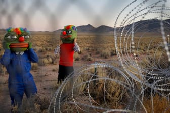 Martin Custodio und Rafael Castillo tragen Pepe-Masken, während sie sich dem Stacheldraht beim Storm Area 51 Basecamp Event nähern: Hunderte Menschen kamen in den 50-Seelen-Ort Rachel im Süden der Wüste des US-Bundesstaates Nevada, um ein Festival zu feiern und zu campen.