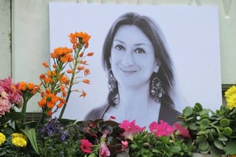 Am Fuß eines Denkmals vor dem Justizpalast in Valletta erinnert ein Foto an die ermordete Journalistin Daphne Caruana Galizia.
