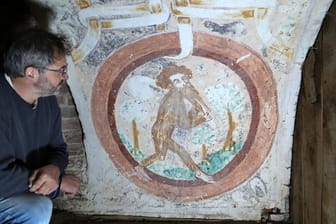 Restaurator Marcus Mannewitz schaut auf eine Wandmalerei mit dem Motiv "Wilder Mann": Die Malerei mit dem sehr ungewöhnlichen Motiv stammt aus der Zeit um 1400 und ist möglicherweise seit jener Zeit nicht angetastet worden.