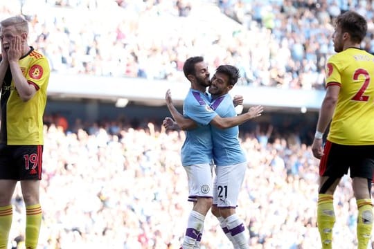 Bernardo Silva (M/l) von Manchester City umarmt David Silva (M/r) nach dem sechsten Treffer gegen Watford.