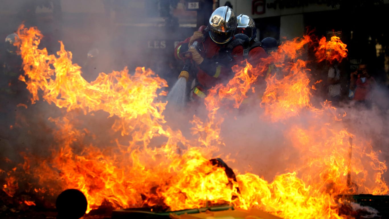 Feuerwehrleute löschen eine brennende Barrikade in Paris: Dort wurden am Samstag mehr als 150 Menschen festgenommen.