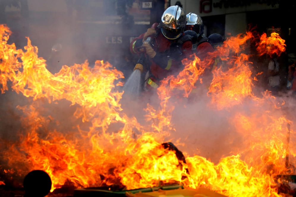 Feuerwehrleute löschen eine brennende Barrikade in Paris: Dort wurden am Samstag mehr als 150 Menschen festgenommen.