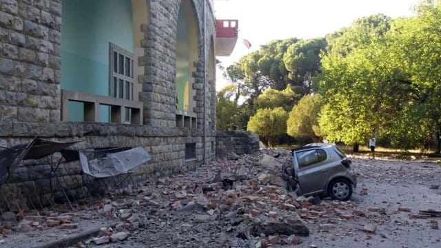 Ein beschädigtes Auto liegt nach einem Erdbeben unter den Trümmern eines Gebäudes in Tirana. Ein beschädigtes Auto liegt nach einem Erdbeben unter den Trümmern eines Gebäudes in Tirana.