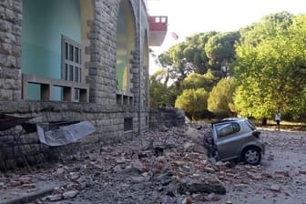 Ein beschädigtes Auto liegt nach einem Erdbeben unter den Trümmern eines Gebäudes in Tirana.