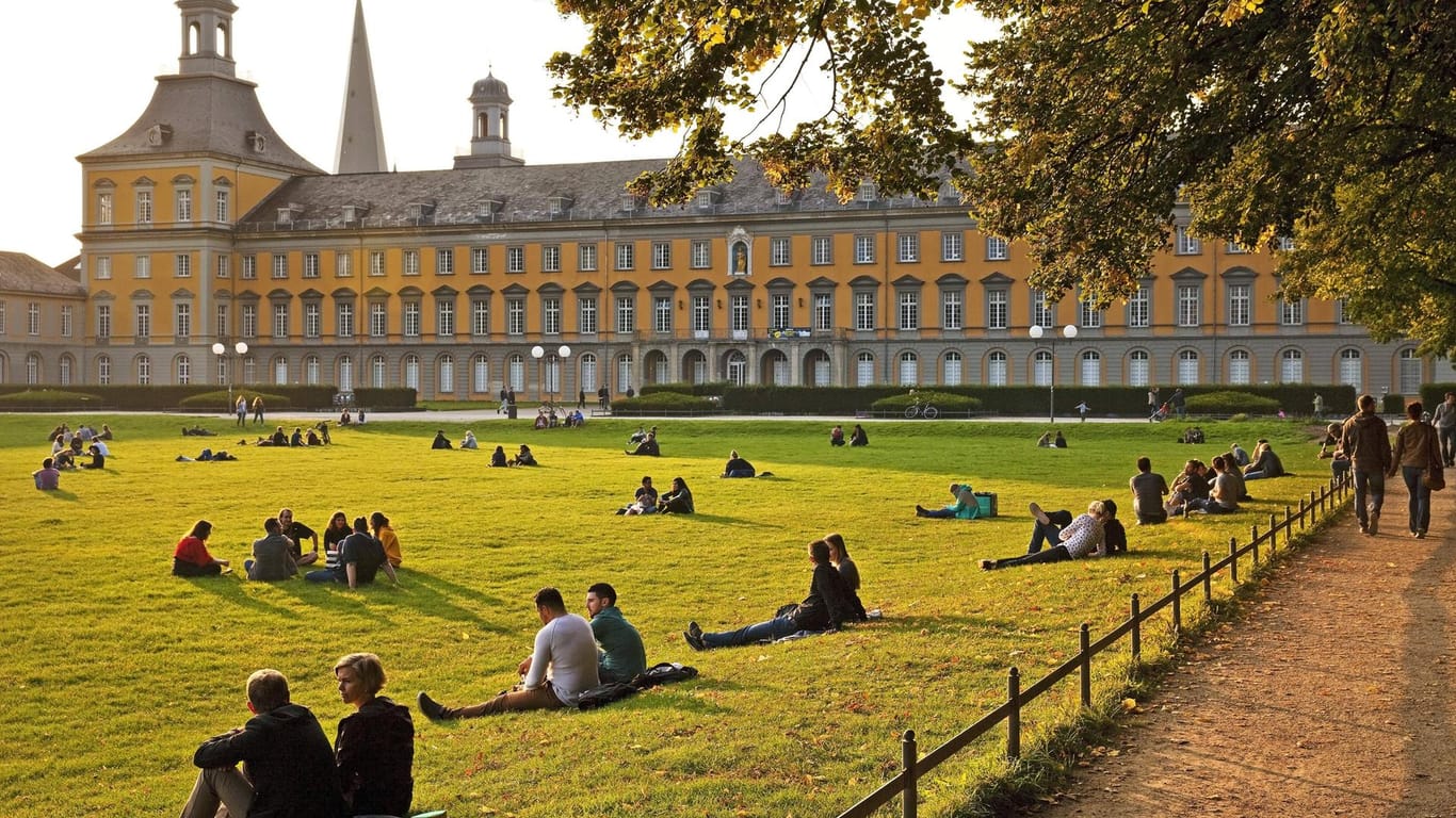 Der Hofgarten vor der Universität in Bonn: Viele Menschen entspannen auf der großflächigen Wiese.