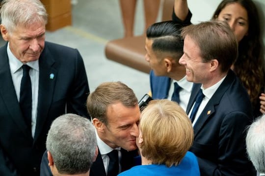 Angela Merkel wird am Rande des UN-Klimagipfels von Emmanuel Macron und Harrison Ford (l) begrüßt.